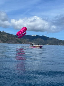 Catalina Xtreme Parasail boat letting parachute up with Catalina Island in the background on a sunny day